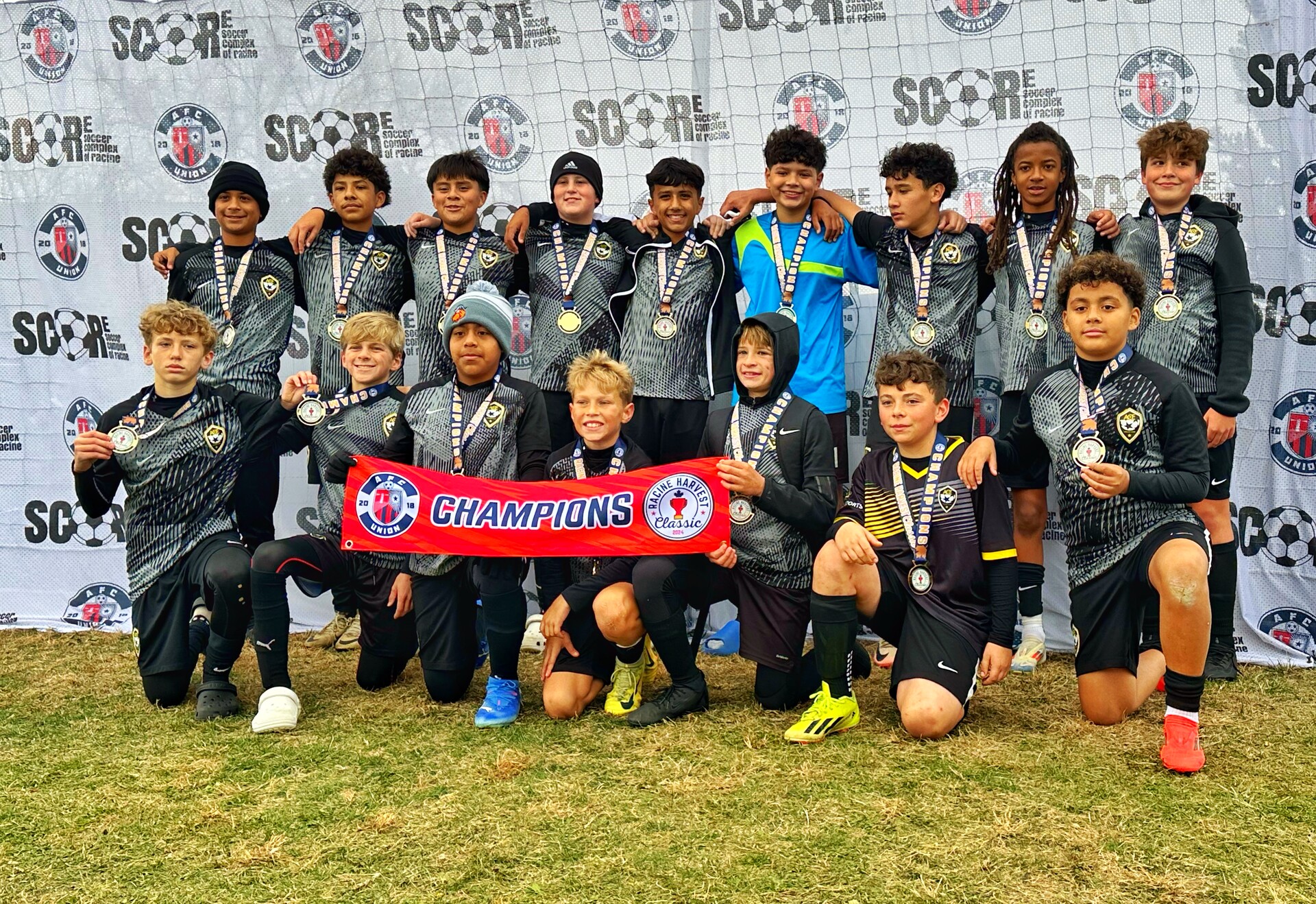 ACE Boys older squad celebrating with Champions banner at SCORE tournament