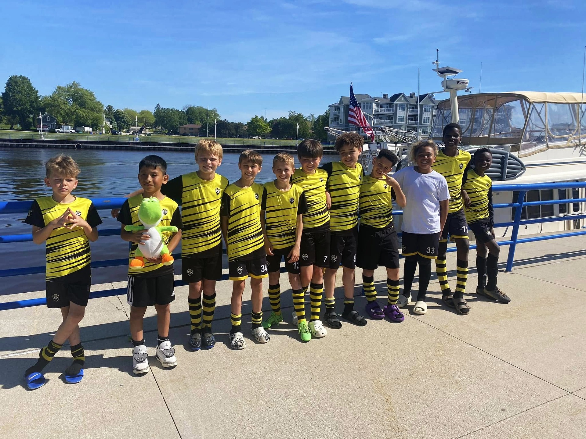 ACE Boys team in striped kits posing by Lake Michigan marina