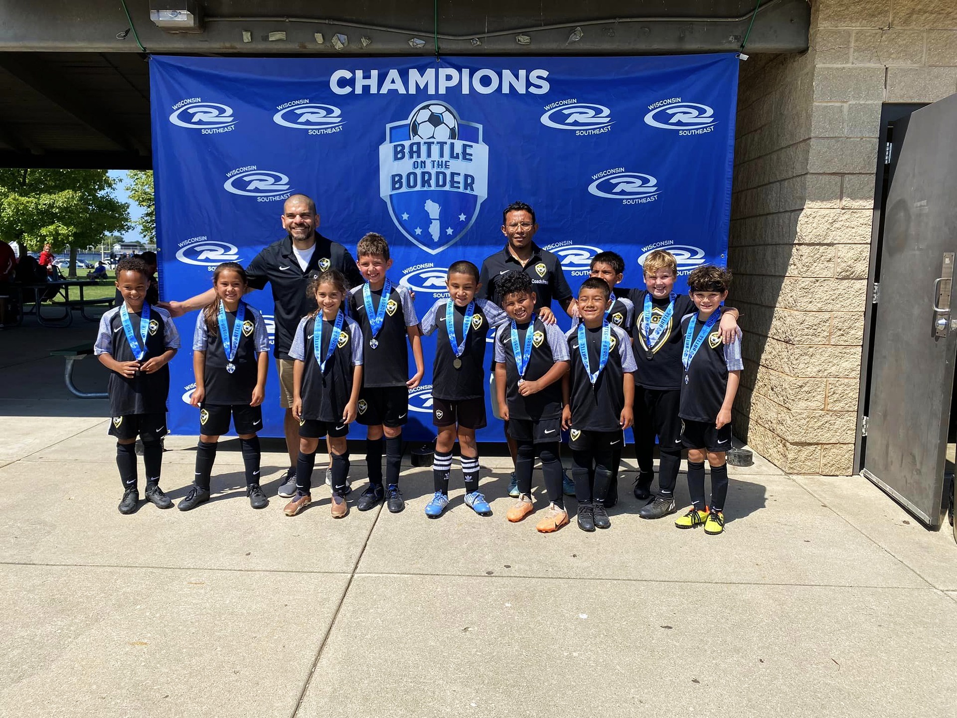 ACE Academy youngest squad with Battle on the Border Champions banner