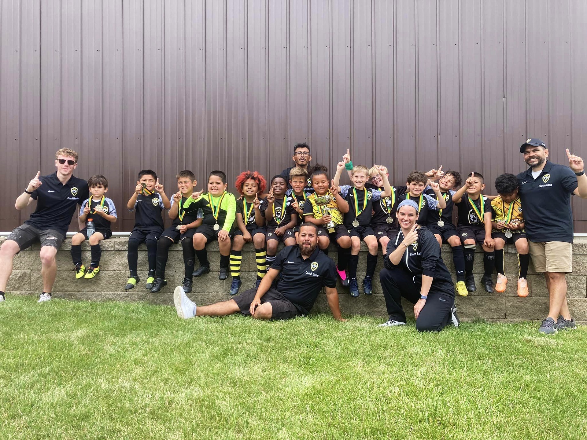ACE team and coaching staff celebrating medals after tournament victory