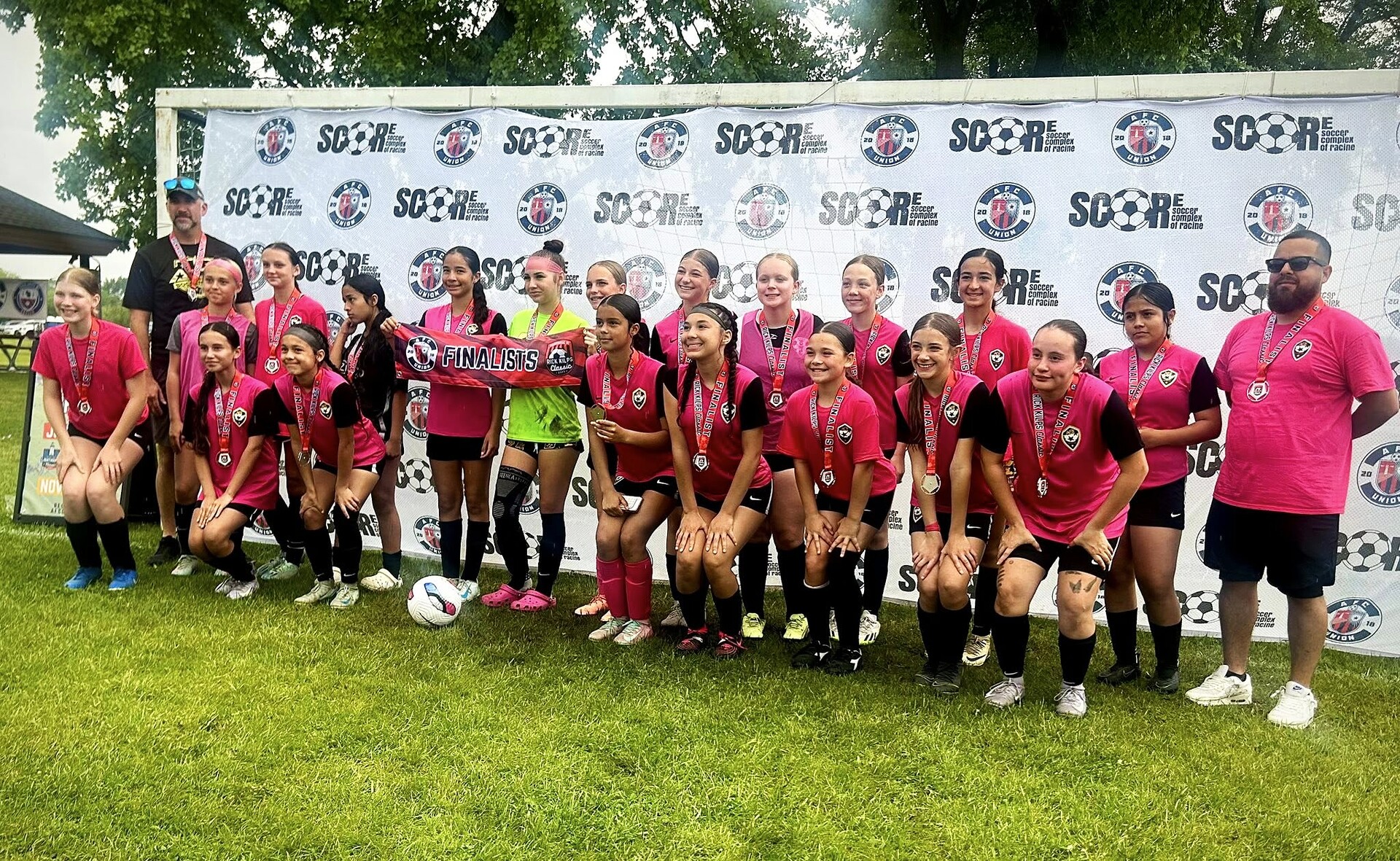 ACE Girls team in pink kits with medals at SCORE tournament finals